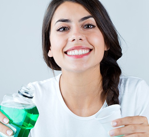 Woman using mouthwash to combat bad breath