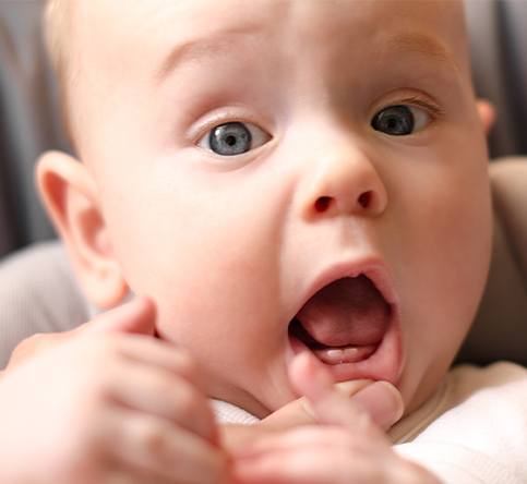 Dentist examining infant after frenectomy for lip and tongue tie
