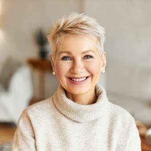 Woman in sweater smiling after cosmetic dentistry in Westchase, FL