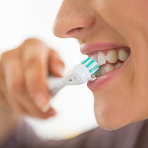 A close-up of a woman brushing her teeth