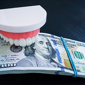 Mouth mold and stack of money between its teeth