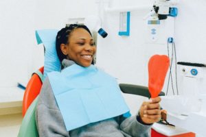 Woman in dentist’s chair looking in mirror